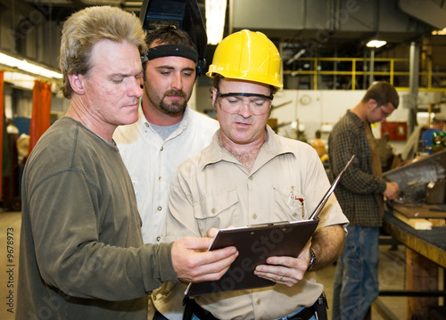 Fotografie, Obraz Factory workers and foreman discuss inspection report