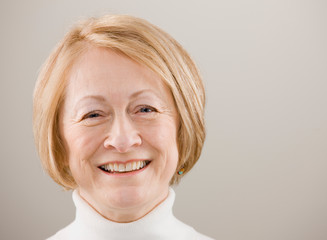 Close up studio shot of happy senior woman