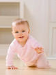 Close up of smiling baby crawling on livingroom floor