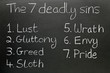 The seven deadly sins, written in chalk on a blackboard.