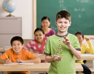 student holding molecular model in science classroom