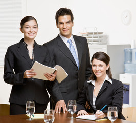 Confident co-workers with paperwork in conference room