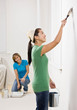 Woman painting with paint brush and renovating home