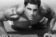 © CURAphotography - young man with naked torso doing push-ups on the beach