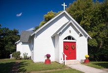 Bright White Chapel With Red Doors Decorated With Fall Flowers
