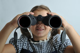 Portrait of a little girl looking through binoculars