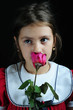 Close up portrait of a little girl smelling a roze