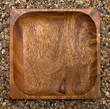 wooden square plate, top view ,against stones
