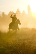Leinwandbild Motiv Cowboy silhouette galloping and roping through the desert