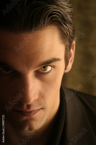 Fotografering half face of a sinister young man with hair back