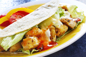 Soft tacos with spicy chicken, salad and sour cream.