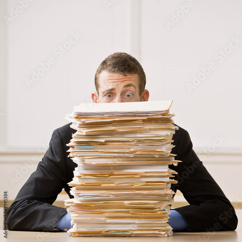 Fotografie, Obraz Frustrated businessman looking at pile of file folders