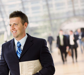 Portrait of successful businessman holding newspaper,