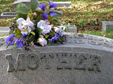 Silk Flowers On A Cemetery Grave Headstone Mother