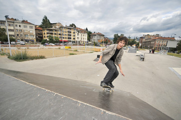 Wall Mural - Boy practicing skate in a skate park - isolated