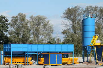 Concrete factory in Poland. Industrial structure and trees.