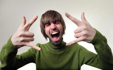 young male with mad face on a grey background