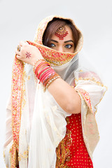 Elegant Bengali bride with veil in front of mouth, isolated