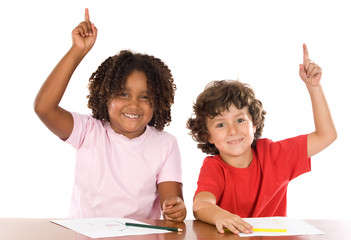 Two student children with their hands raised up