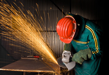 Wall Mural - heavy industry manual worker with grinder background