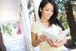 © Stephen Coburn - A pretty asian woman at home reading on the porch