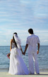 bride and groom standing hands at the beach