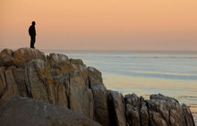 Man By Himself On Cliff Overlooking Sea