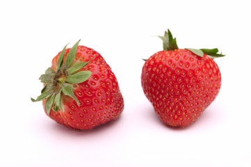 Two fresh strawberries on a white background