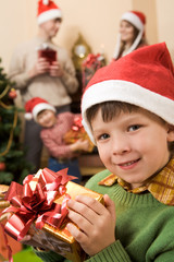 Wall Mural - Image of glad boy with Christmas present