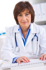 Wall Mural - Senior female doctor working on computer at offiice.