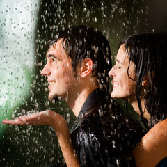 Wall Mural - young happy amorous couple hugging under a rain