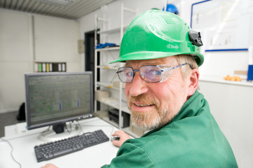 Wall Mural - Industrial worker in his office in front of a pc