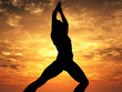Man doing yoga exercises in sunset