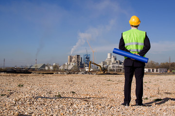 young architect in front of industrial construction site