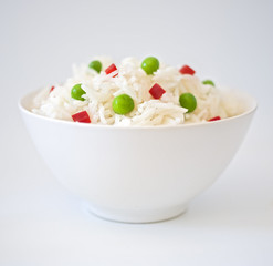 Wall Mural - bowl of rice with peas an peppres on white