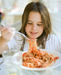 young girl eating spaghetti in restaurent
