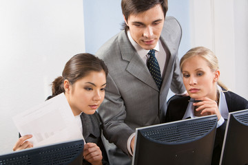 Canvas Print - Portrait of three business partners in front of computer