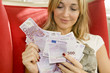Attractive woman takes lot of 500 euro banknotes.