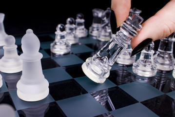 A shot of a chess game with a woman moving the king