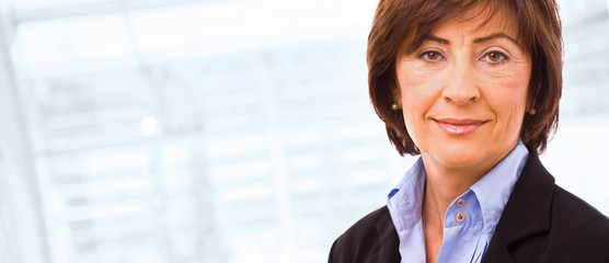 Canvas Print - Portrait of senior businesswoman at office lobby.