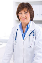 Wall Mural - Portrait of senior female doctor working at office.