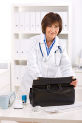 Portrait of happy senior female doctor at office, smiling.