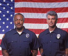 Two Policemen In Front Of Flag