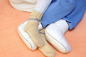 Two Couple's feet warming at a bed