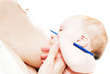 Newborn baby with blue pen and breasfeeding