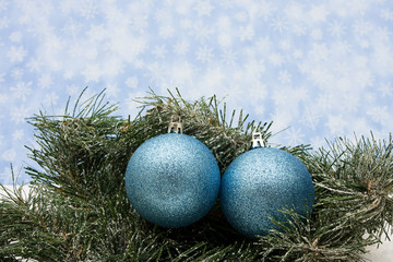 Green garland on snowflake background with blue glass balls