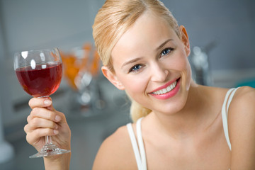 Wall Mural - Young woman with red wine at kitchen