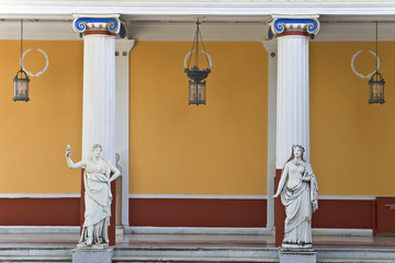 Wall Mural - Ancient Greek statues standing outside a classic temple