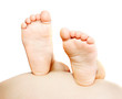© Alena Yakusheva - child's feet on pregnant tummy over white