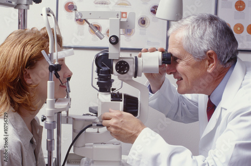 Fotomural optometrist with patient, giving an eye examination